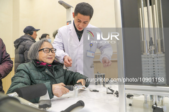 An elderly man is being escorted by medical staff during rehabilitation training in the rehabilitation sports function room of the Wuyang St...