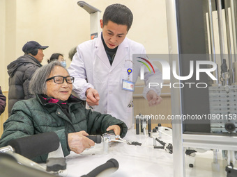 An elderly man is being escorted by medical staff during rehabilitation training in the rehabilitation sports function room of the Wuyang St...