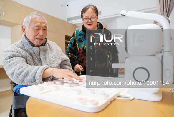 An elderly man is playing chess with a robot at Daoxin Nursing Home on Wuyang Street in Deqing County, Huzhou, China, on January 9, 2024. 