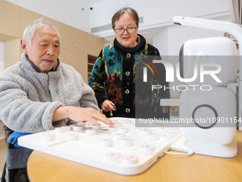 An elderly man is playing chess with a robot at Daoxin Nursing Home on Wuyang Street in Deqing County, Huzhou, China, on January 9, 2024. (