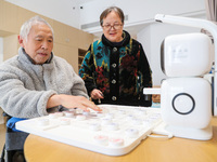 An elderly man is playing chess with a robot at Daoxin Nursing Home on Wuyang Street in Deqing County, Huzhou, China, on January 9, 2024. (