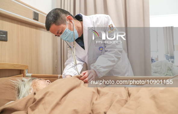 A medical worker from a community health service center is checking an elderly person at Daoxin Nursing Home on Wuyang Street in Deqing Coun...