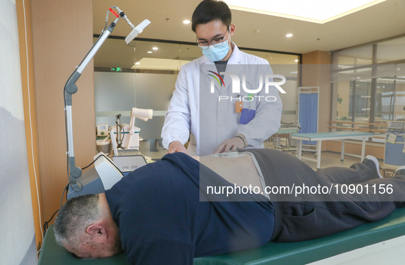 A medical worker is performing traditional Chinese medicine therapy for an elderly person at a community health service center on Wuyang Str...