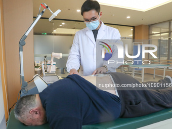 A medical worker is performing traditional Chinese medicine therapy for an elderly person at a community health service center on Wuyang Str...