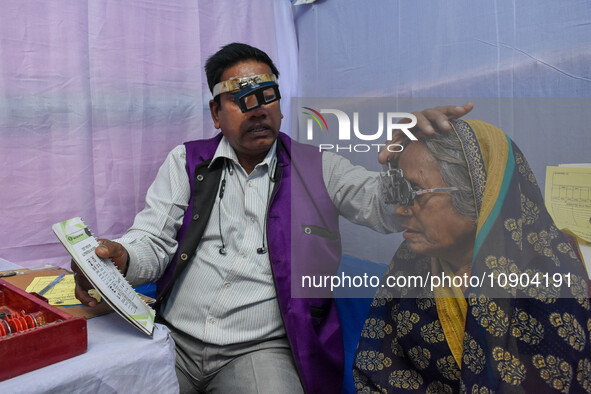 A doctor is checking the eyesight of a traveling devotee at a free checkup camp in Gangasagar transit camp in Kolkata, India, on January 11,...