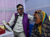 A doctor is checking the eyesight of a traveling devotee at a free checkup camp in Gangasagar transit camp in Kolkata, India, on January 11,...