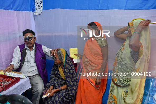 A doctor is checking the eyesight of a traveling devotee at a free checkup camp in Gangasagar transit camp in Kolkata, India, on January 11,...