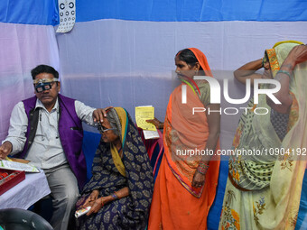 A doctor is checking the eyesight of a traveling devotee at a free checkup camp in Gangasagar transit camp in Kolkata, India, on January 11,...