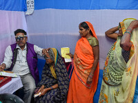 A doctor is checking the eyesight of a traveling devotee at a free checkup camp in Gangasagar transit camp in Kolkata, India, on January 11,...