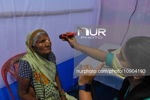 A doctor is checking the eyesight of a traveling devotee at a free checkup camp in Gangasagar transit camp in Kolkata, India, on January 11,...