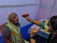 A doctor is checking the eyesight of a traveling devotee at a free checkup camp in Gangasagar transit camp in Kolkata, India, on January 11,...