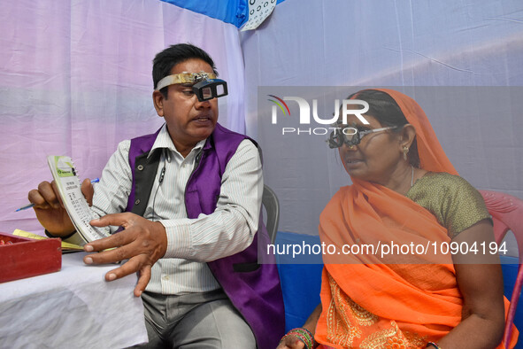 A doctor is checking the eyesight of a traveling devotee at a free checkup camp in Gangasagar transit camp in Kolkata, India, on January 11,...