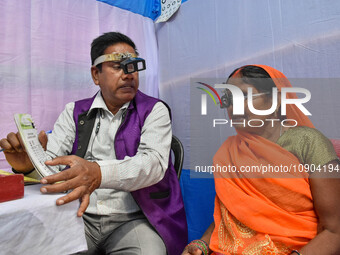 A doctor is checking the eyesight of a traveling devotee at a free checkup camp in Gangasagar transit camp in Kolkata, India, on January 11,...