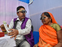 A doctor is checking the eyesight of a traveling devotee at a free checkup camp in Gangasagar transit camp in Kolkata, India, on January 11,...