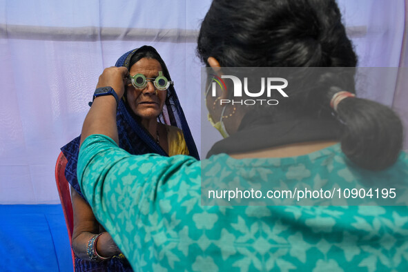 A doctor is checking the eyesight of a traveling devotee at a free checkup camp in Gangasagar transit camp in Kolkata, India, on January 11,...