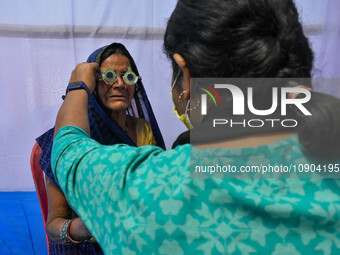 A doctor is checking the eyesight of a traveling devotee at a free checkup camp in Gangasagar transit camp in Kolkata, India, on January 11,...