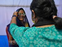 A doctor is checking the eyesight of a traveling devotee at a free checkup camp in Gangasagar transit camp in Kolkata, India, on January 11,...