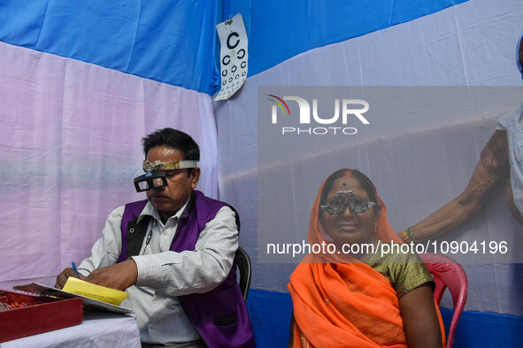 A doctor is checking the eyesight of a traveling devotee at a free checkup camp in Gangasagar transit camp in Kolkata, India, on January 11,...