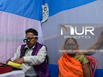 A doctor is checking the eyesight of a traveling devotee at a free checkup camp in Gangasagar transit camp in Kolkata, India, on January 11,...