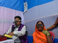 A doctor is checking the eyesight of a traveling devotee at a free checkup camp in Gangasagar transit camp in Kolkata, India, on January 11,...