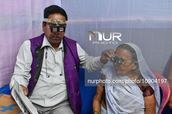 A doctor is checking the eyesight of a traveling devotee at a free checkup camp in Gangasagar transit camp in Kolkata, India, on January 11,...