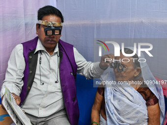 A doctor is checking the eyesight of a traveling devotee at a free checkup camp in Gangasagar transit camp in Kolkata, India, on January 11,...