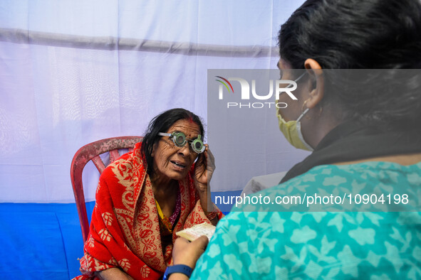 A doctor is checking the eyesight of a traveling devotee at a free checkup camp in Gangasagar transit camp in Kolkata, India, on January 11,...