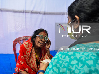 A doctor is checking the eyesight of a traveling devotee at a free checkup camp in Gangasagar transit camp in Kolkata, India, on January 11,...