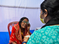 A doctor is checking the eyesight of a traveling devotee at a free checkup camp in Gangasagar transit camp in Kolkata, India, on January 11,...