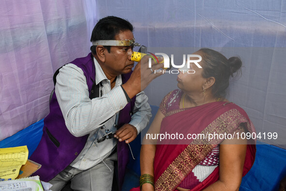 A doctor is checking the eyesight of a traveling devotee at a free checkup camp in Gangasagar transit camp in Kolkata, India, on January 11,...