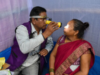 A doctor is checking the eyesight of a traveling devotee at a free checkup camp in Gangasagar transit camp in Kolkata, India, on January 11,...