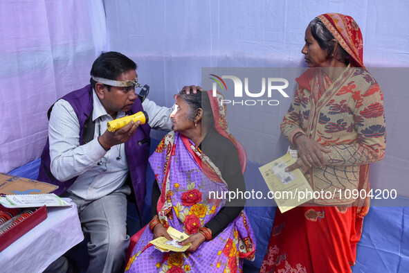 A doctor is checking the eyesight of a traveling devotee at a free checkup camp in Gangasagar transit camp in Kolkata, India, on January 11,...