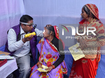 A doctor is checking the eyesight of a traveling devotee at a free checkup camp in Gangasagar transit camp in Kolkata, India, on January 11,...