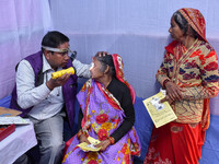 A doctor is checking the eyesight of a traveling devotee at a free checkup camp in Gangasagar transit camp in Kolkata, India, on January 11,...