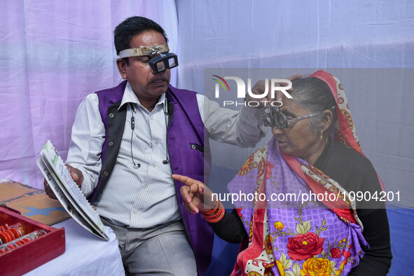 A doctor is checking the eyesight of a traveling devotee at a free checkup camp in Gangasagar transit camp in Kolkata, India, on January 11,...