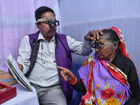 A doctor is checking the eyesight of a traveling devotee at a free checkup camp in Gangasagar transit camp in Kolkata, India, on January 11,...