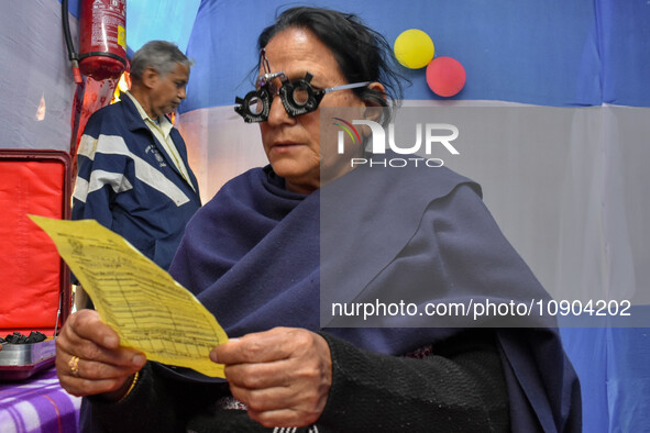 A doctor is checking the eyesight of a traveling devotee at a free checkup camp in Gangasagar transit camp in Kolkata, India, on January 11,...