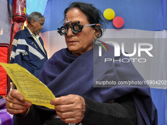 A doctor is checking the eyesight of a traveling devotee at a free checkup camp in Gangasagar transit camp in Kolkata, India, on January 11,...