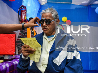 A doctor is checking the eyesight of a traveling devotee at a free checkup camp in Gangasagar transit camp in Kolkata, India, on January 11,...