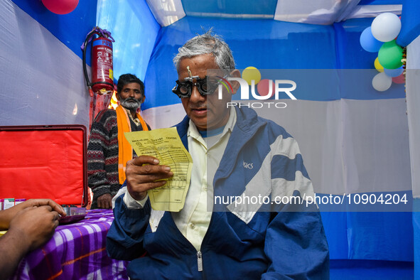 A doctor is checking the eyesight of a traveling devotee at a free checkup camp in Gangasagar transit camp in Kolkata, India, on January 11,...