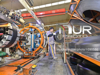 A worker is working on the production line of a tire manufacturing company in the Qingzhou Economic Development Zone, in Qingzhou, China, on...