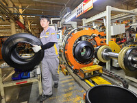 A worker is working on the production line of a tire manufacturing company in the Qingzhou Economic Development Zone, in Qingzhou, China, on...