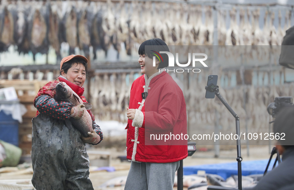 A worker is promoting cured fish through an online live broadcast in Huai'an, China, on January 14, 2024. 