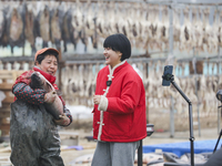 A worker is promoting cured fish through an online live broadcast in Huai'an, China, on January 14, 2024. (