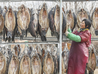 A worker is drying cured fish in Huai'an, China, on January 14, 2024. (