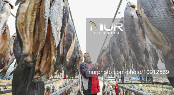 A worker is drying cured fish in Huai'an, China, on January 14, 2024. 