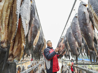 A worker is drying cured fish in Huai'an, China, on January 14, 2024. (