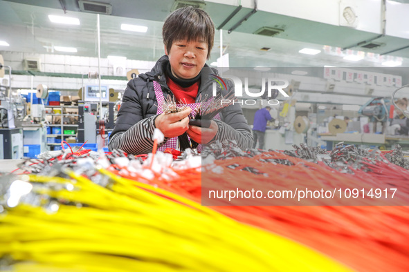 A worker is producing PTC heating block products at a micro factory in Xiashe village, Huzhou, China, on January 15, 2024. 