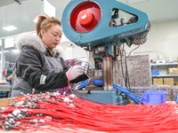 A worker is producing PTC heating block products at a micro factory in Xiashe village, Huzhou, China, on January 15, 2024. (