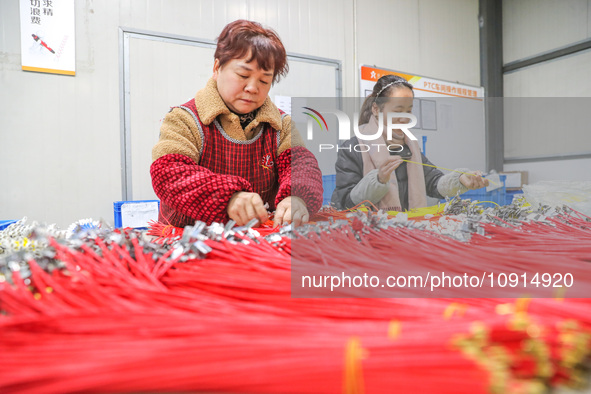 A worker is producing PTC heating block products at a micro factory in Xiashe village, Huzhou, China, on January 15, 2024. 